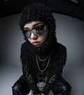 Edgy opium fashion model in spiked black hood, sunglasses, and fringed knit top, Affect—Crew style.