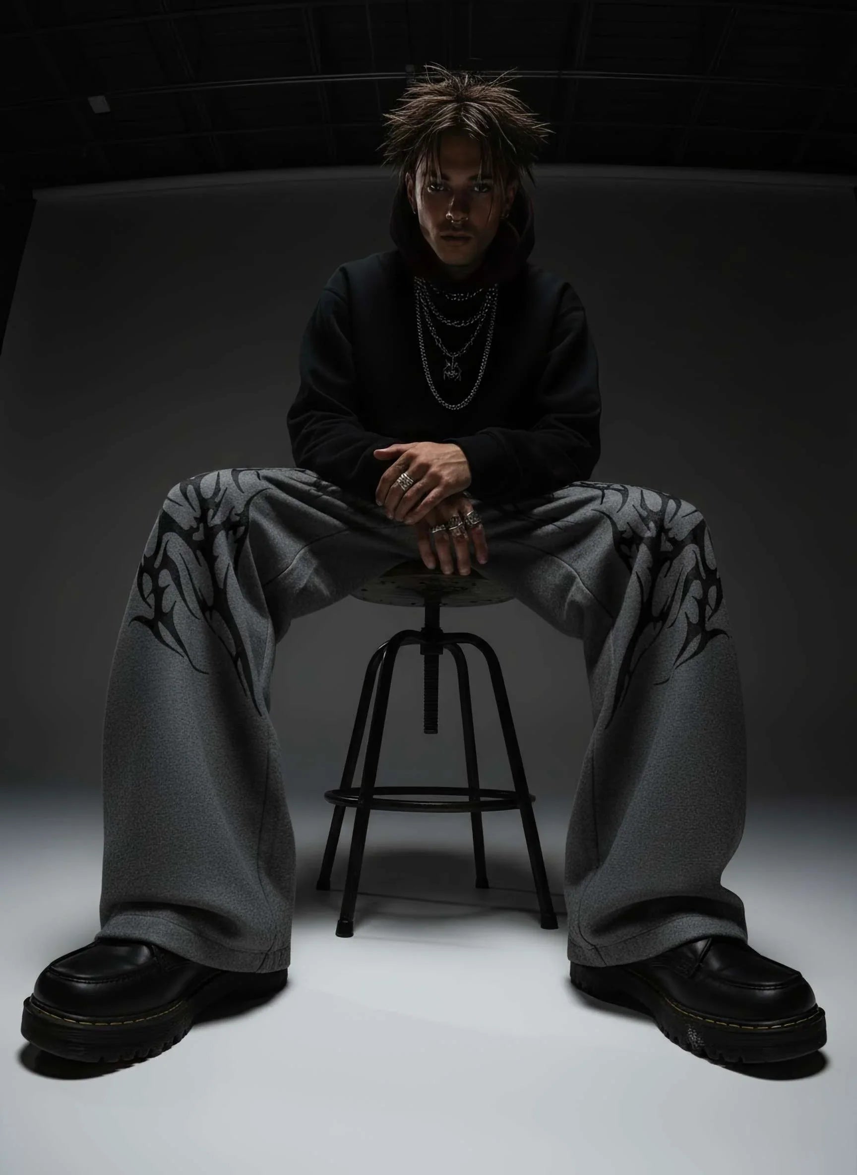 Person sitting on a stool in a dark room with minimal lighting