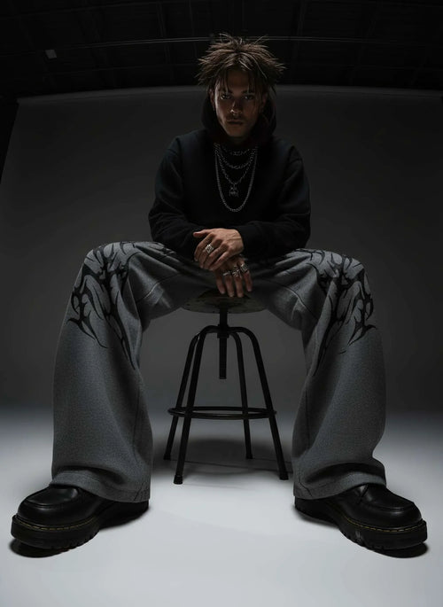Person sitting on a stool in a dark room with minimal lighting