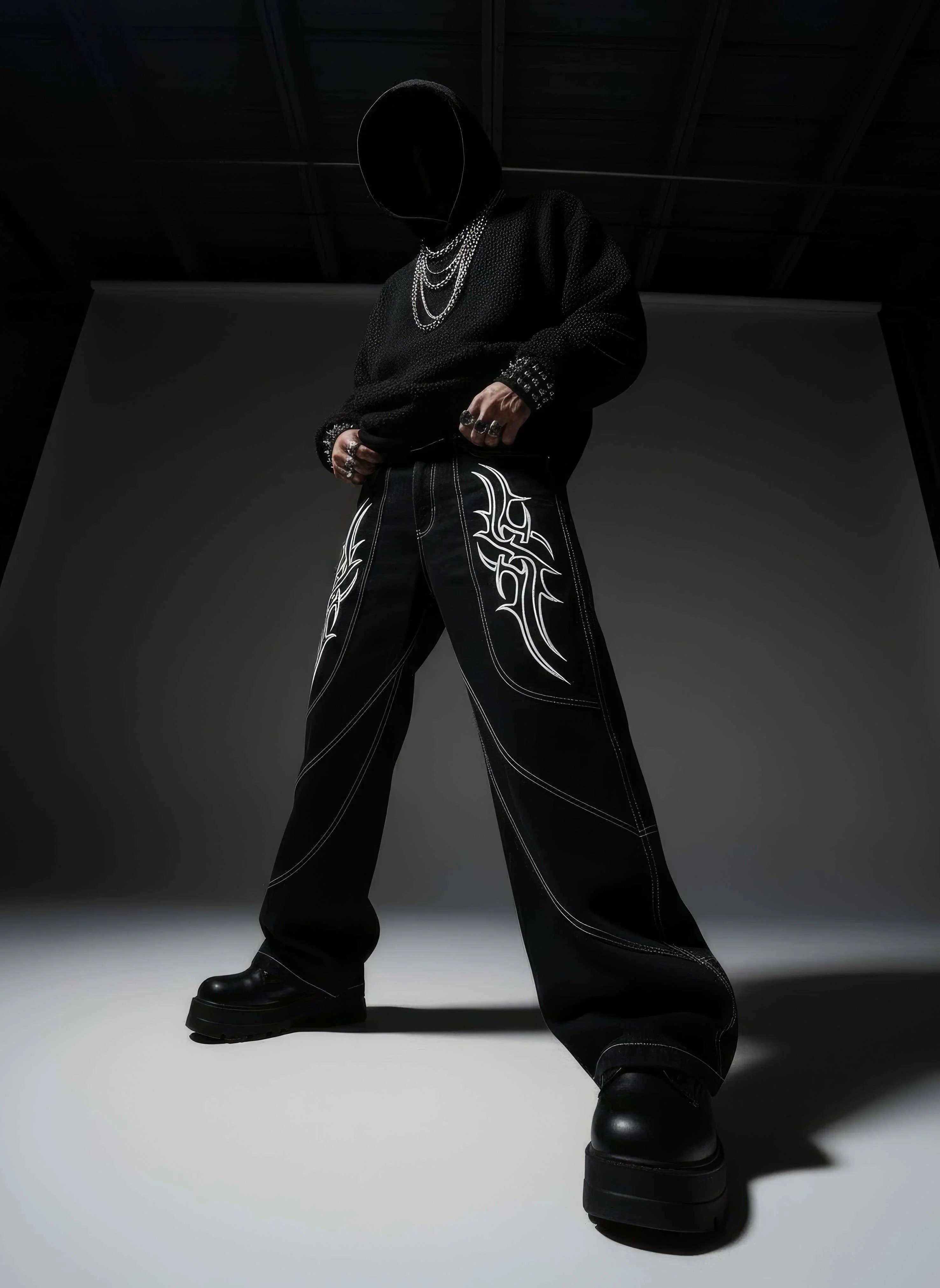 Person wearing a black outfit with white patterns in a dark room