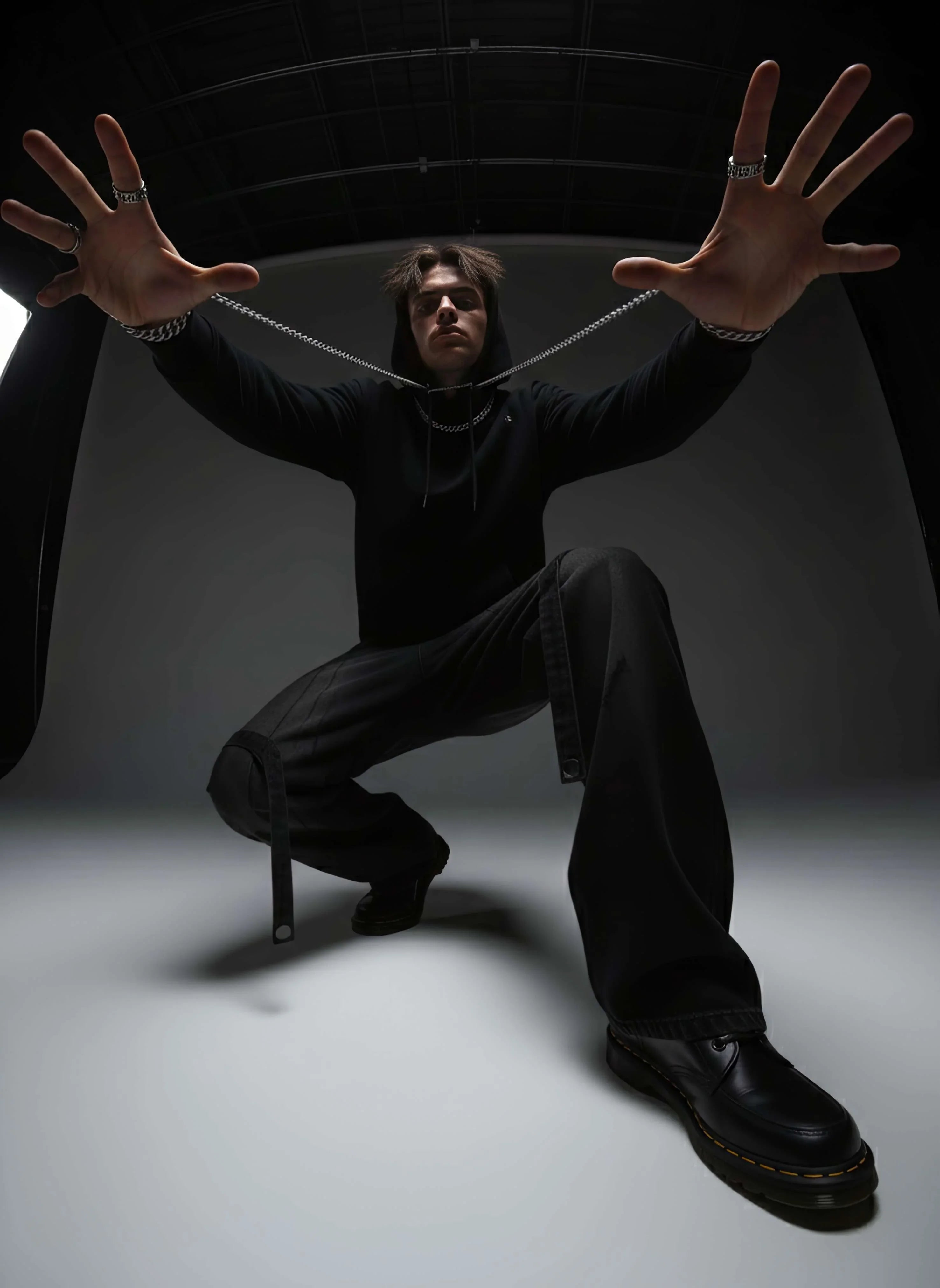 Model in black distressed cargo wide leg jeans, hoodie, and chunky shoes, edgy fashion style