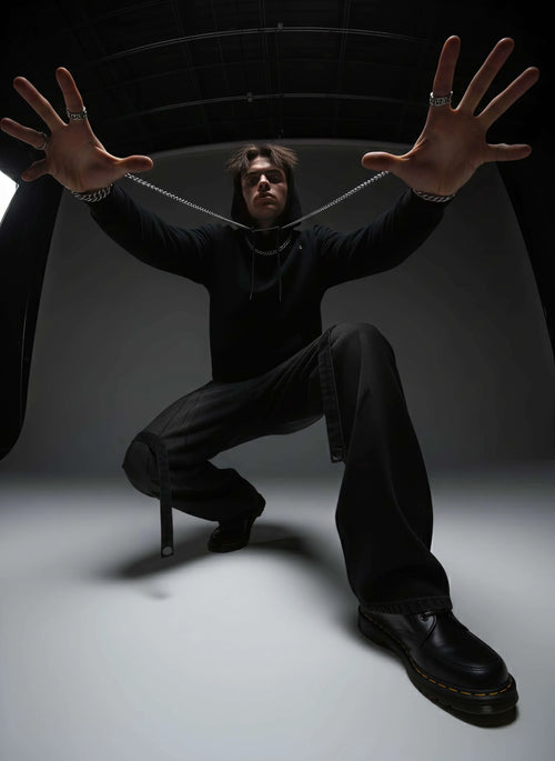 Model in black distressed cargo wide leg jeans, hoodie, and chunky shoes, edgy fashion style